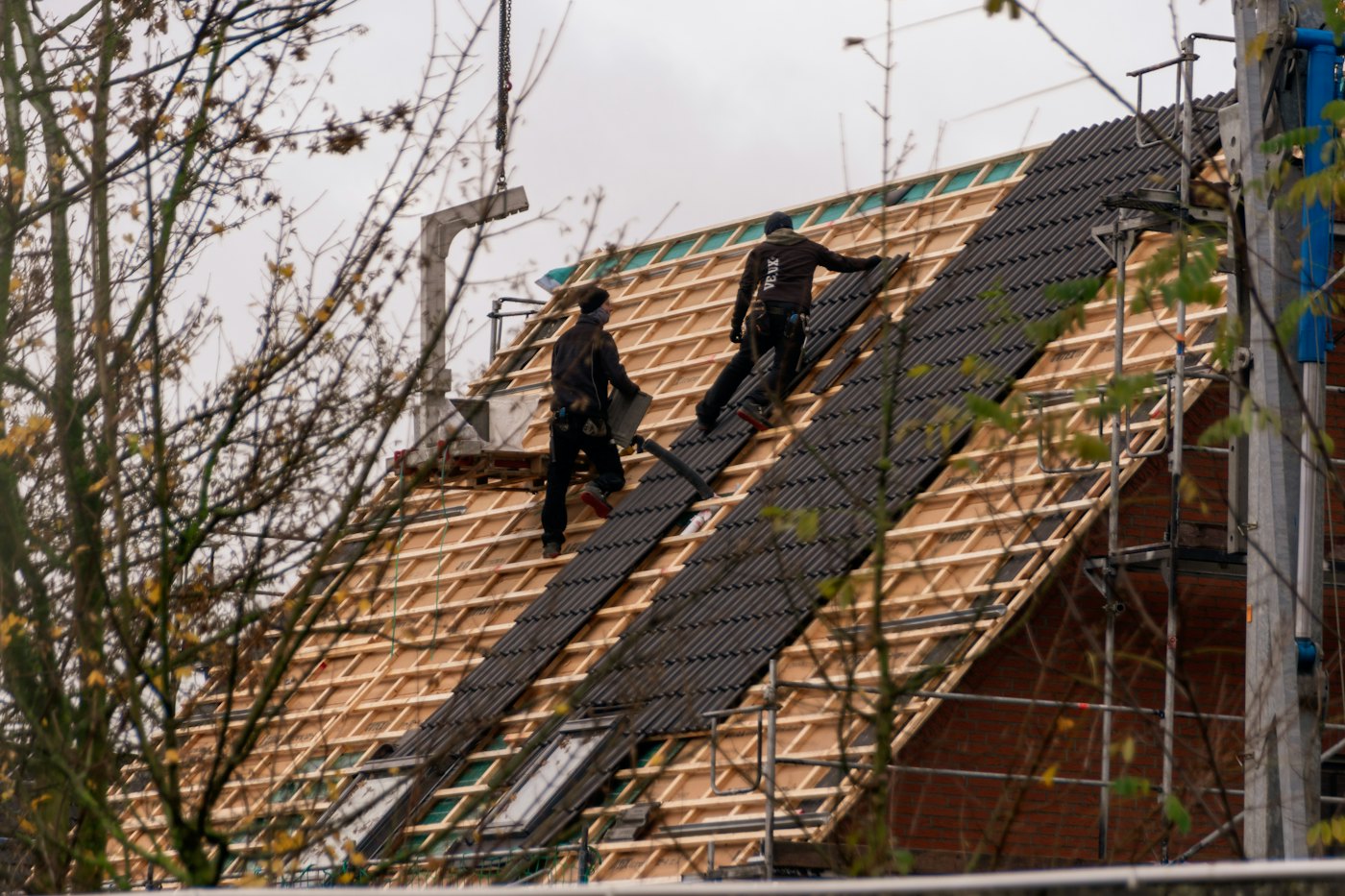 Illustrative photo of roofers installing shingles